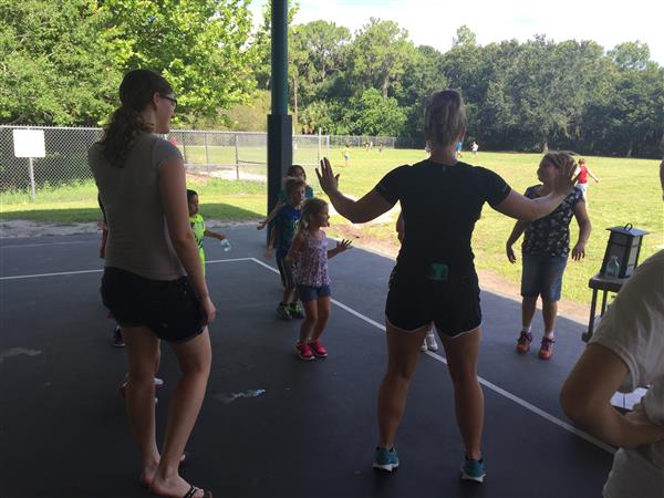 teachers and students do jumping jacks outside